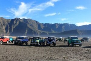 4WD jeep parked at the Sea of Sand in Mount Bromo with Mount Batok in the background, commonly used for Mount Bromo jeep rentals.