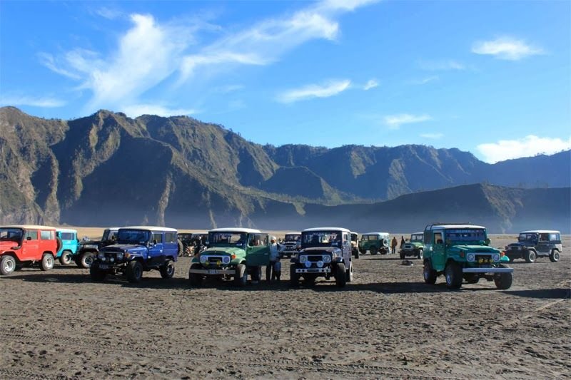 4WD jeep parked at the Sea of Sand in Mount Bromo with Mount Batok in the background, commonly used for Mount Bromo jeep rentals.