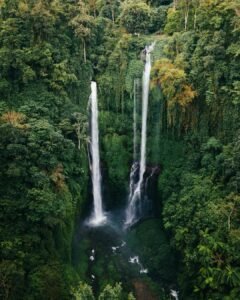 Hidden Sekumpul Waterfall flowing between steep green cliffs