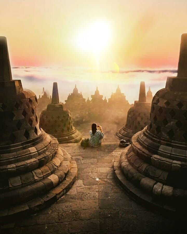 Borobudur Temple at sunrise with visitors exploring terraces, Yogyakarta, Indonesia