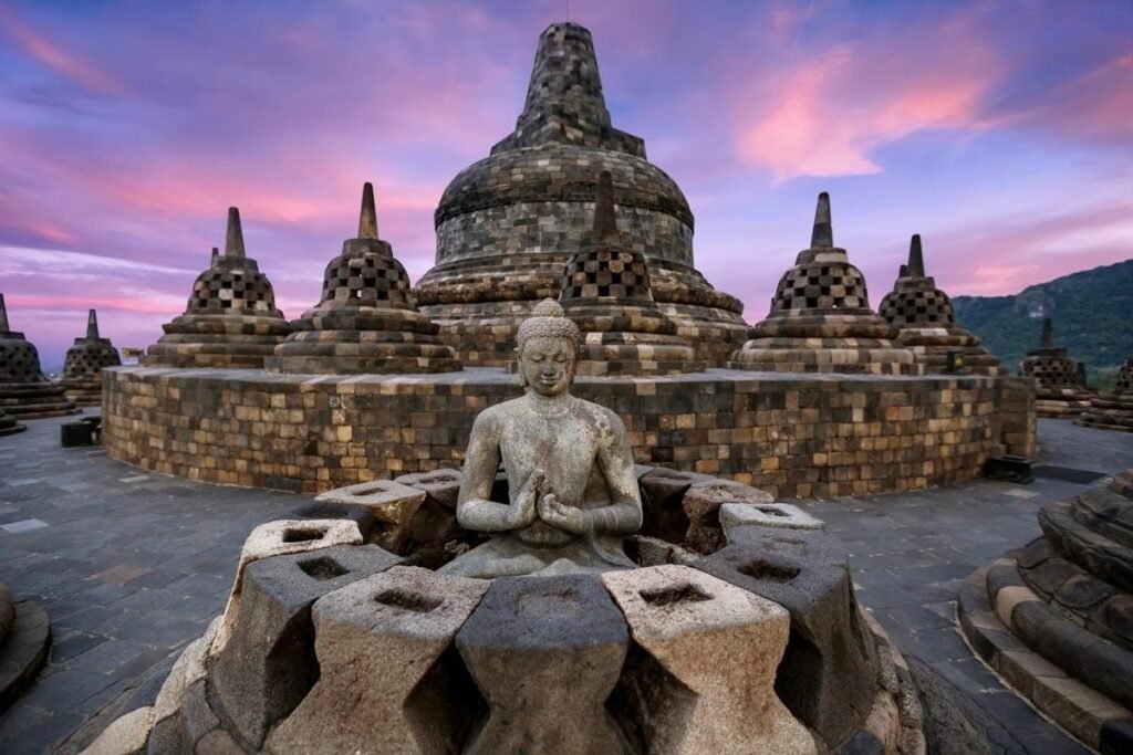 Visitors exploring Borobudur Temple in Yogyakarta, Indonesia, showing entrances, pathways, and Buddha statues